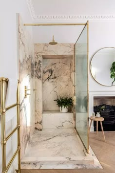 a bathroom with marble walls and flooring in white, gold and black colors is shown