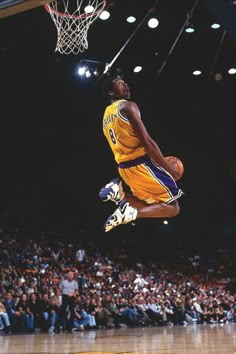 a basketball player jumping up into the air to dunk a ball in front of an audience