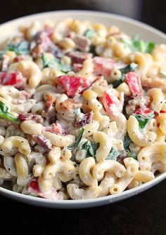 a white bowl filled with macaroni salad on top of a black countertop