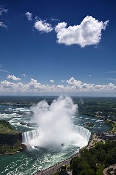 an aerial view of niagara falls and the canadian side with clouds in the blue sky