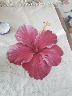 a pink flower is on a white cloth