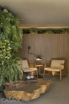 a living room with two chairs and a table in front of a plant wall on the other side