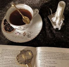 a cup of tea next to an open book