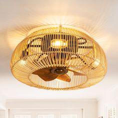 a fan that is hanging from the ceiling in a room with white walls and flooring