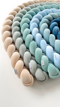 several pillows stacked on top of each other in the shape of a spiral design, with price tags attached to them