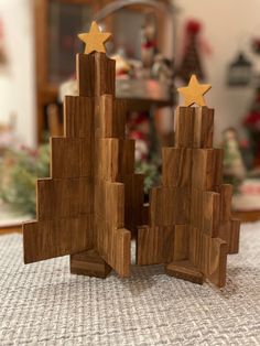 two wooden christmas trees with gold stars on them