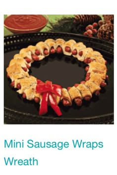 a christmas wreath made out of crackers with hotdogs on them and a red bow