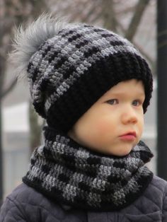 a little boy wearing a knitted hat and scarf