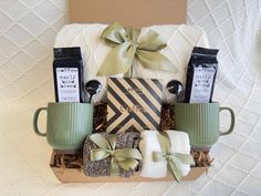 a gift box with coffee, tea and other items in it sitting on a bed