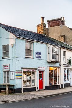 an old blue building on the corner of a street