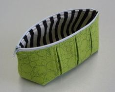 a green and black zippered pouch sitting on top of a table