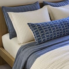 a bed with blue and white pillows on it