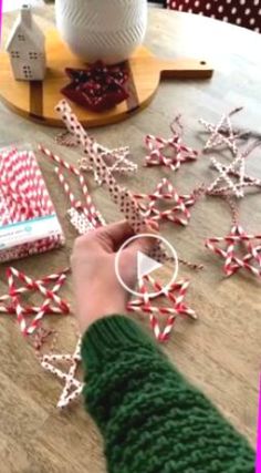 a person is making christmas decorations out of candy canes on a table with other items