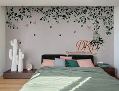 a bed sitting under a tree next to a wall with birds flying over the branches