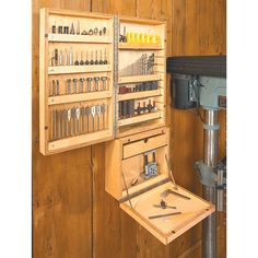 a workbench with many tools in it hanging on the wall next to a driller