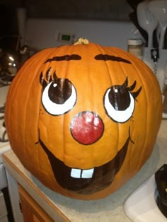 a pumpkin with an evil face painted on it's side sitting on a kitchen counter