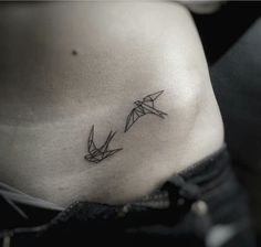 a woman's stomach with an origami bird tattoo on her left side