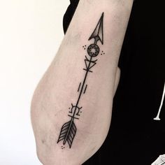 an arrow tattoo on the left arm