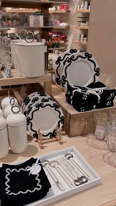 the table is set with black and white dishes, silverware, and other items