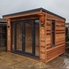 a small wooden building with sliding glass doors