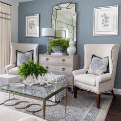 a living room with blue walls and white furniture in the center, along with a large mirror on the wall