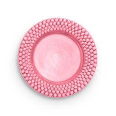 a pink plate with beading on the rim is shown in front of a white background