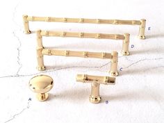 three pieces of brass hardware on a white surface