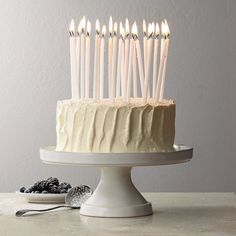 a cake with white frosting and lit candles