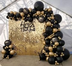 black and gold balloons in front of a golden backdrop