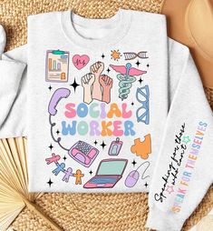 a white sweatshirt with the words social worker printed on it next to some other items