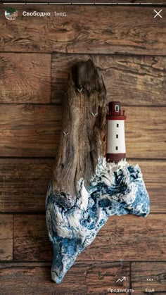 a piece of driftwood with a lighthouse on it sitting on top of a wooden floor