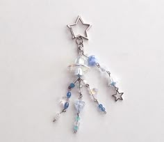 a star shaped keychain with beads and charms hanging from it's side