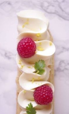 a piece of bread topped with whipped cream and raspberries