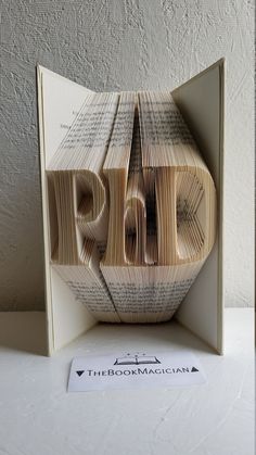 an origami book sculpture with the word pdd cut out of it's pages