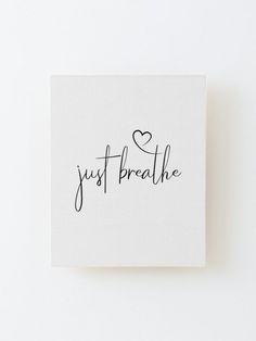 a white square with the words just breathe written in cursive writing on it