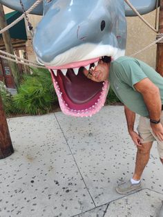 a man standing next to a giant fake shark