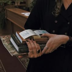 a woman holding several books in her hands