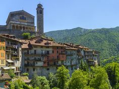 an old building in the middle of a forest with mountains in the background - stock photo - images