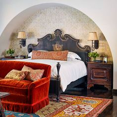 a large bed sitting next to a red chair in a bedroom