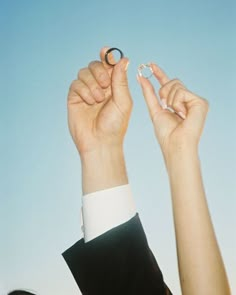 a woman holding up two rings in the air