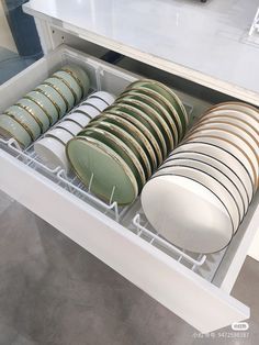 there are many plates and bowls in the dishwasher drawer that is open to show them