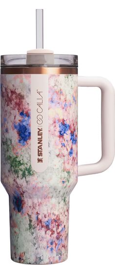 thermos travel mug is decorated with colorful flowers and has a straw in it