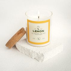 a white candle sitting on top of a piece of paper next to a wooden stick