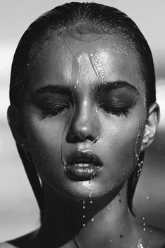 a woman with water on her face and nose is shown in black and white photo