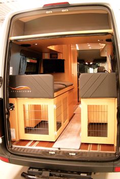 an open van with two dogs in it's kennels on the back