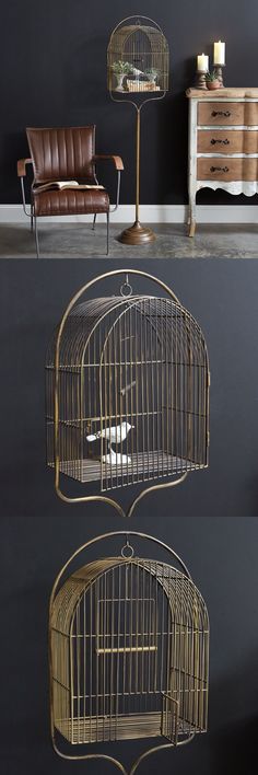 three bird cages with one open and the other closed, in front of a black wall