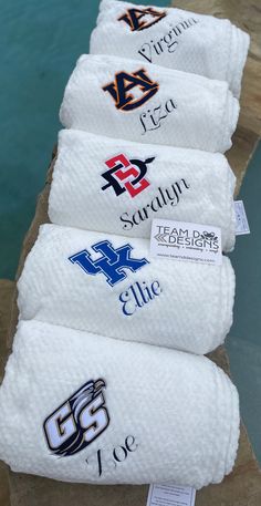 towels are lined up on the edge of a pool to be used as personalized items