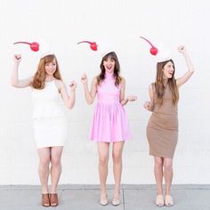 three young women in dresses and hats are posing for the camera with their arms up