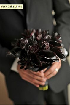 a man in a suit holding a bouquet of flowers