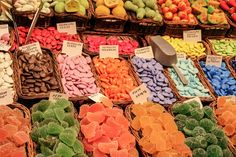 many different colored candies in baskets on display